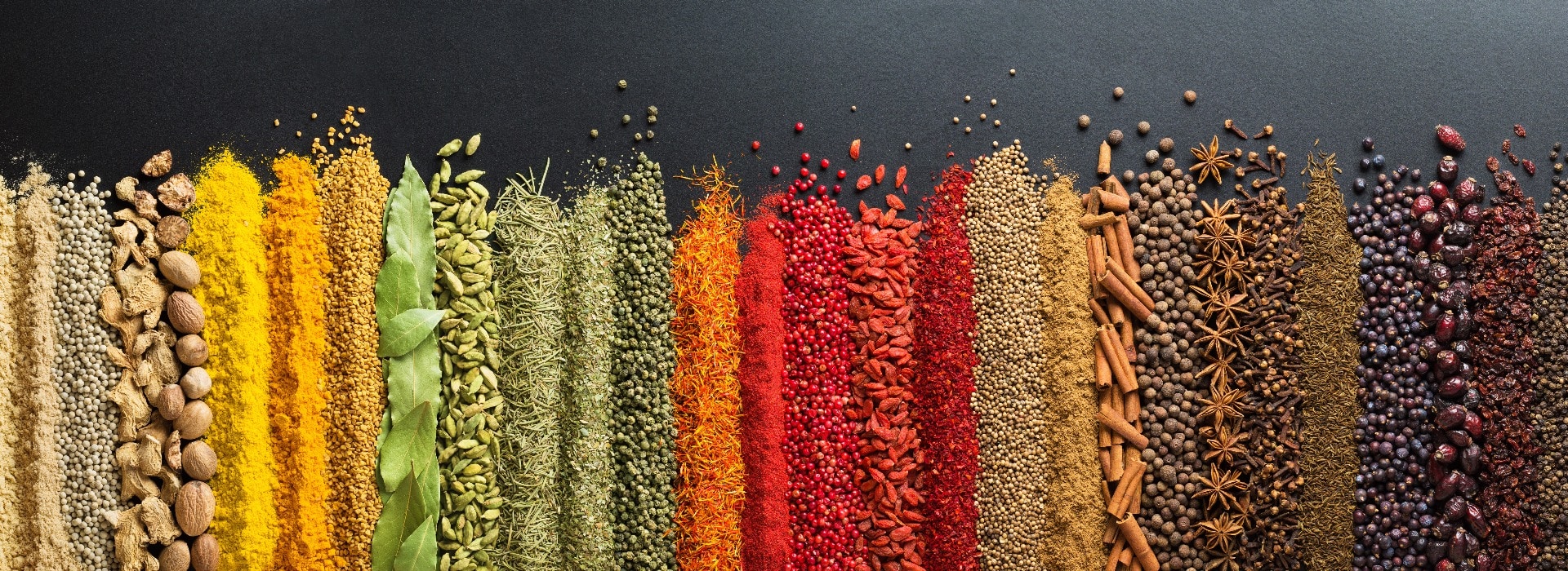 Colorful collection spices and herbs on background black table. Mediterranean condiments for decorating packing with food.